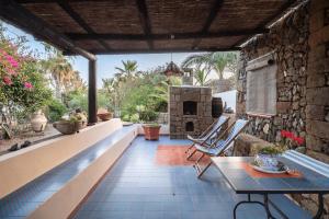 een patio met een tafel en een stenen oven bij Appartamento Esperanza Amarillo in Scauri
