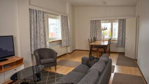 ein Wohnzimmer mit Sofa, Fernseher und Tisch in der Unterkunft Citimotel in Lappeenranta