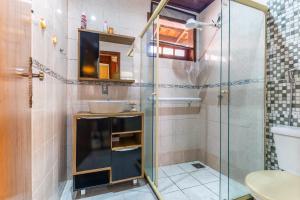 een badkamer met een glazen douche en een wastafel bij Aconchego in Mangaratiba +8 foto's