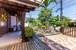een huis met een terras met een tafel en stoelen bij Aconchego in Mangaratiba