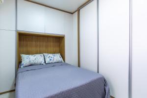 een slaapkamer met een bed en witte kasten bij Aconchego in Mangaratiba