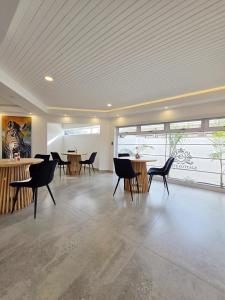 White Cottage Boutique Guesthouse في سواكوبموند: غرفة بها كراسي وطاولات ونافذة كبيرة