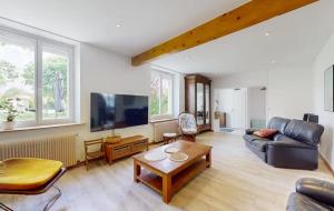 a living room with a couch and a table at Maison Charentaise 12 à 14 personnes in Sémussac