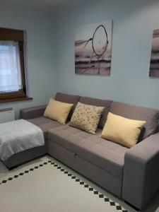 sala de estar con sofá gris y almohadas amarillas en Apartamento El Fondon 1, en Cangas de Onís 9 fotos más