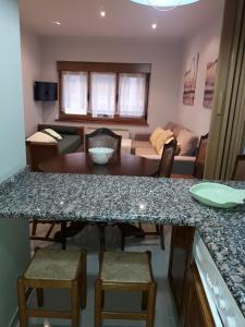 Una cocina y una sala de estar con mesa y sillas. en Apartamento El Fondon 1, en Cangas de Onís