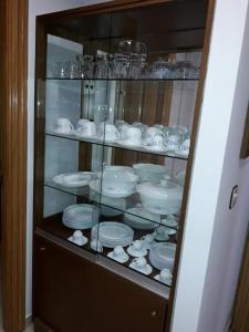 un armario de cristal lleno de platos y platos en Apartamento El Fondon 1, en Cangas de Onís