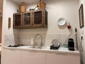 een keuken met een spoelbak en houten kasten bij Loft VITA LENTA 2 in Bari