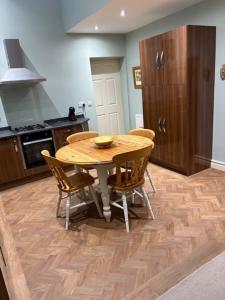 a kitchen with a wooden table and chairs at Hatters Cottage Eldwick Bingley Yorkshire in Bingley