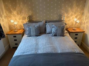 a bedroom with a blue bed with two night stands at Hatters Cottage Eldwick Bingley Yorkshire in Bingley
