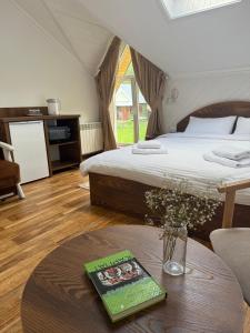 Un dormitorio con una cama y una mesa con un libro en Сироварня Далекі Гори, en Snidavka