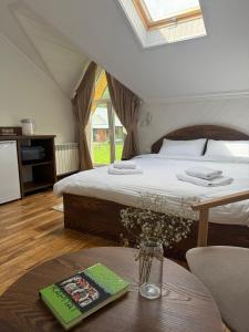 Un dormitorio con una cama y una mesa con un libro en Сироварня Далекі Гори, en Snidavka 14 fotos más