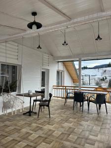 porche con mesa y sillas en el suelo de madera en Сироварня Далекі Гори, en Snidavka