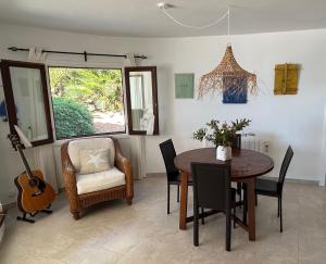 a dining room with a table and a guitar at Villa Florencia in Son Bou