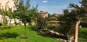 a garden with two trees and a brick wall at In-giardino in Osigo