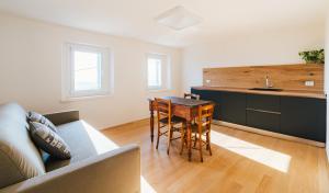 a living room with a table and a kitchen at In-giardino in Osigo +9 photos