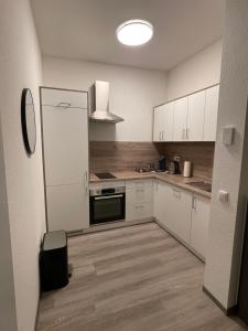 a kitchen with white cabinets and a refrigerator at 36 Nürburgring in Mayen in Mayen