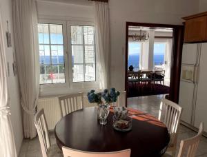 a dining room with a table and chairs with a view of the ocean at Art Blue Residence - Panorama Maisonette in Aghia Marina