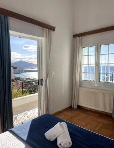 a bedroom with a bed and a large window at Art Blue Residence - Panorama Maisonette in Aghia Marina