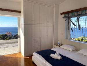 a bedroom with a bed and a large window at Art Blue Residence - Panorama Maisonette in Aghia Marina +13 photos