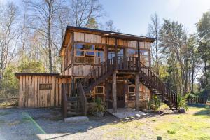 uma casa na árvore com uma escada num quintal em Pucón Rec-Lodge Cabaña Carpintero em Pucón