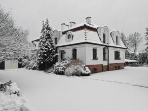 a house covered in snow in a yard at Apartament Krzemienna in Bielsko-Biała