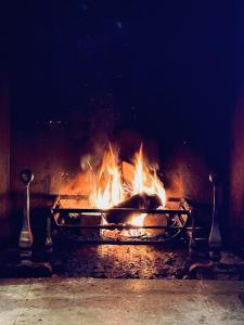 un fuoco in un camino con le fiamme dentro di Finstock Manor a Finstock