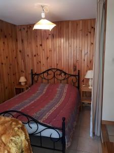 a bedroom with a bed in a room with wooden walls at Gite Le Vignou À Ste-enimie in Prades