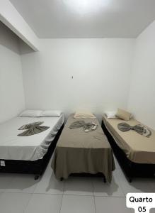 due letti uno accanto all'altro in una stanza di Casa Fundo de Quintal a Trairi