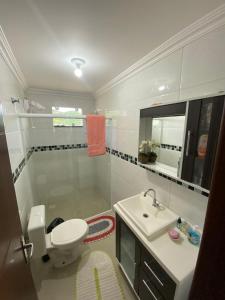 Un baño con un inodoro blanco y un lavabo. en Beautiful house for up to 5 people, en Porto Belo