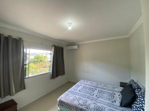 Un dormitorio con una cama y una ventana en Beautiful house for up to 5 people, en Porto Belo