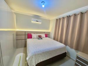 Dormitorio pequeño con cama con almohadas rosas en Beautiful house for up to 5 people, en Porto Belo