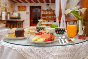 uma mesa coberta com pratos de comida e sobremesas em VELINN Pousadas Flor da Montanha em Monte Verde