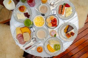 uma mesa com muitos pratos de comida em VELINN Pousadas Flor da Montanha em Monte Verde