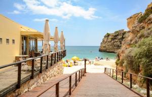 Eine Promenade entlang eines Strandes mit Sonnenschirmen und dem Meer in der Unterkunft B30 - Apartment T2 in Alvor in Alvor