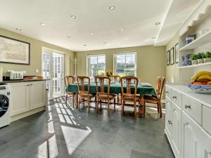 una cucina e una sala da pranzo con tavolo e sedie di 5 Bed in Conwy 48169 a Eglwys-Fâch