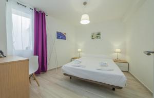 een slaapkamer met een bed en een paars gordijn bij B21 - Oliveira Cozy Flat in Lagos