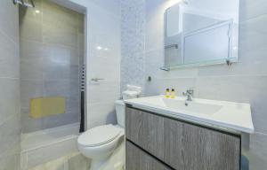 een witte badkamer met een toilet en een wastafel bij B21 - Oliveira Cozy Flat in Lagos +65 foto's