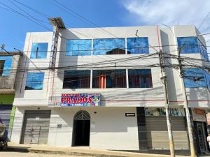 a white building with a sign in front of it at Hotel PRADO'S in Satipo