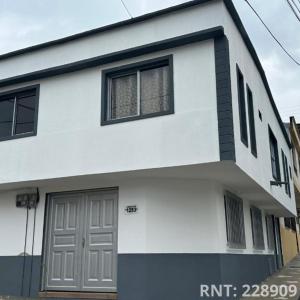 Espectacular apto cerca a la Zona Rosa في سانتا روزا دي كابال: منزل أبيض وأسود مع مرآب للسيارات