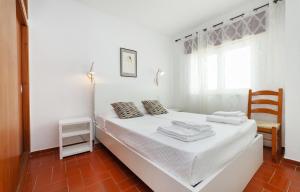 Una cama blanca en una habitación con ventana. en B14 - Heart of Old Town Apartment, en Lagos