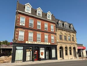 a large brick building on the corner of a street at The Scotsman Inn in Pictou