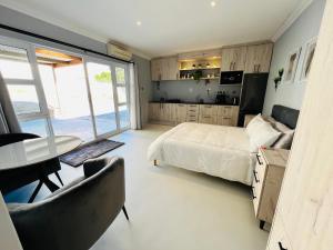 a bedroom with a bed and a table and chairs at Rissie's Villa in Gordonʼs Bay