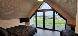 a bedroom with a large window in a house at Black barn in Rusinowo