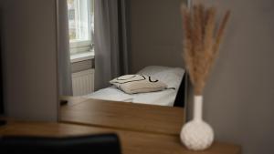 a mirror on a table with a pillow and a vase at Citimotel in Lappeenranta