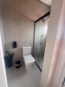 a bathroom with a toilet and a glass shower at Pousada Sete Colinas in Bragança Paulista +11 photos