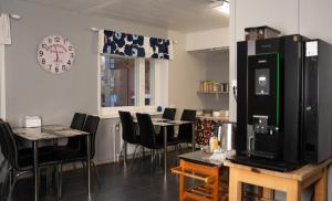 ein Restaurant mit Tischen und Stühlen und einer Uhr an der Wand in der Unterkunft Citimotel in Lappeenranta