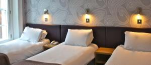 a hotel room with two beds and a table at Hotel PRADO'S in Satipo