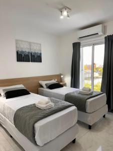 una camera da letto con due letti e una finestra di Vela Villa Apart a Villa Ángela