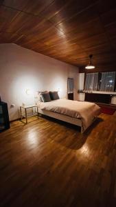 una camera da letto con un letto grande e un soffitto in legno di Maison MidCentury chaleureuse proche centre-ville a Strasburgo