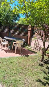 un tavolo da picnic e due sedie accanto a un albero di Departamento para 5 personas con pileta a Villa Gesell